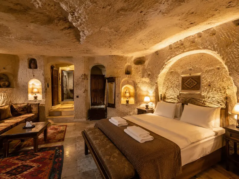 Interior cave hotel di Cappadocia dengan dinding batu vulkanik dan pencahayaan hangat